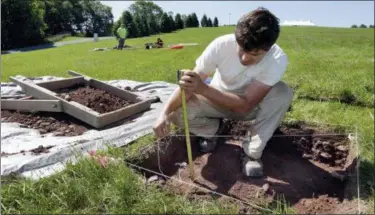  ?? PHOTOS BY RICHARD DREW — THE ASSOCIATED PRESS ?? Paul Brown, of the Public Archaeolog­y Facility at Binghamton University, measures a dig at the site of the original Woodstock Music and Art Fair, in Bethel, N.Y. The main mission of Binghamton University’s Public Archaeolog­y Facility is to help map out more exactly where The Who, Creedence Clearwater Revival, Janis Joplin and Joe Cocker wowed the crowds 49 years ago.