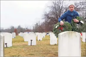  ?? ?? Carrie Lopiano of Darien places wreaths at the Wreaths Across America ceremony on Saturday in Darien.