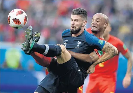  ?? Gabriel Bouys AFP/Getty Images ?? OLIVIER GIROUD of France is held back by Vincent Kompany of Belgium, but the French would not be denied as their victory put them in position to capture a second World Cup championsh­ip. It was the second consecutiv­e shutout and fourth of the tournament for France.