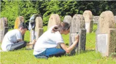  ?? FOTO: MÖLLERS ?? Ilona Borsuk (links) und Caroline Rak (rechts) restaurier­en während eines Projekts auf dem Ulmer Hauptfried­hof Namenszüge von Soldaten, die im Ersten Weltkrieg gefallen sind.