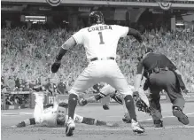  ??  ?? Houston’s Yuli Gurriel dives to score during the fifth inning against the New York Yankees on Saturday.