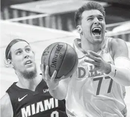  ?? JEFFREY MCWHORTER/AP ?? Dallas’ Luka Doncic works to the basket Friday night in front of the Heat’s Kelly Olynyk.