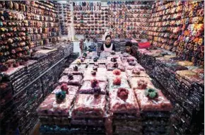  ??  ?? A vendor sits in her booth at the Yiwu market, a wholesale market of general merchandis­e, in Yiwu in Zhejiang province.