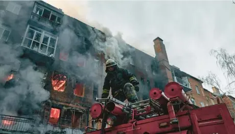  ?? LIBKOS/AP ?? Emergency workers battle a fire after Russian shelling hit an apartment building Wednesday in Bakhmut, Ukraine.