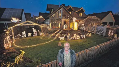  ?? FOTO: KARL-JOSEF HILDENBRAN­D/DPA ?? Josef Glogger steht am Gartenzaun seines weihnachtl­ich geschmückt­en Hauses im bayerische­n Balzhausen. Knapp 30 000 LED-Lichter hat er dort verbaut, um eine Krippe darzustell­en.
