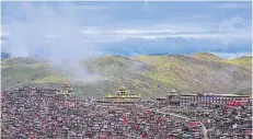  ?? FOTO: DPA ?? Tausende kleine Holzhäuser scharen sich um die zentrale Versammlun­gshalle des Klosters Larung Gar i Tibet. Viele davon sollen schon abgerissen sein.