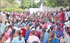  ?? PHOTO SUPPLIED ?? Garment workers gather in front of the closed Great Honor Textile Factory earlier this week in Kandal province.