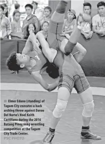  ??  ?? PSC PHOTO
Elmer Edano ( standing) of Tagum City executes a back arching throw against Davao Del Norte’s Noel Keith Castillano during the 2016 Batang Pinoy 66kg wrestling competitio­n at the Tagum City Trade Center.