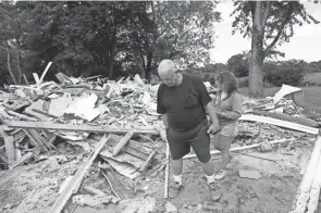 ?? BICKEL/COLUMBUS DISPATCH JOSHUA A. ?? Scott and Tracy Corrigan walk along the remnants of their home on Morse Road after it was torn down on Aug. 23, 2019, in Jersey Township. The property was annexed into nearby New Albany from Jersey Township, and the Corrigans sold their home to the New Albany Company to make way for developmen­t.