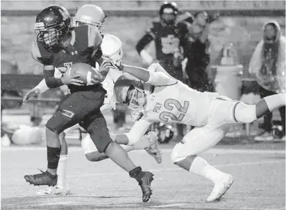  ?? KARL MERTON FERRON/BALTIMORE SUN ?? City running back Dominic Hill drags Poly defender Seth Scott while gaining a first down during the 130th City-Poly rivalry game.