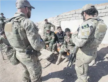  ?? RYAN REMIORZ / THE CANADIAN PRESS ?? Canadian special forces soldiers speak with Kurdish peshmerga fighters at an observatio­n post in northern Iraq in February. Kurds are fighting to establish an independen­t Kurdistan, which is opposed by Iraq and Turkey.