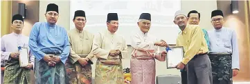  ??  ?? Taib (fifth left) presenting ‘Wakaf’ certificat­e to one of the recipients. From second left are Abang Mohammad Shibli, Dr Abdul Rahman, Misnu, Lee (partly hidden) and Kipli.
