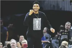  ?? DAVID DERMER/AP ?? Milwaukee Bucks forward Giannis Antetokoun­mpo cheers from the bench in the first half of an NBA basketball game against the Cleveland Cavaliers, Sunday in Cleveland.