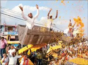  ?? ?? Bharatiya Janata Party supporters sprinkle flower petals during a road show by BJP National President J.P. Nadda (unseen), in Tumakuru, Karnataka on 18 March. ANI