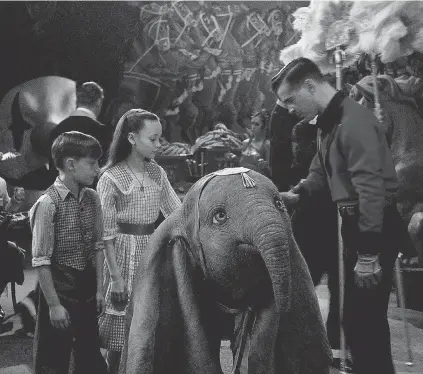  ??  ?? Holt Farrier (Colin Farrell) and his children Joe (Finley Hobbins) and Milly (Nico Parker) become caretakers for a flying baby elephant in Tim Burton's “Dumbo.” DISNEY