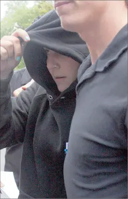  ?? PICTURE: WESLEY FESTER ?? ACCUSED: Talana-Jo Huysamer, accused of a racist attack, tries to hide from photograph­ers as she leaves the Wynberg Magistrate’s Court this week.