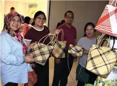  ??  ?? Rosni and family look at rattan baskets displayed for sale.