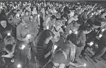  ?? Yi-Chin Lee / Houston Chronicle ?? Hundreds of people take part in a candleligh­t vigil for Marcus McGhee, who was found dead Saturday morning, floating in a lake on his uncle’s property in Pearland.