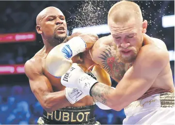  ?? — Reuters photo ?? Floyd Mayweather Jr lands a hit against Conor McGregor during their boxing match at the at T-Mobile Arena.