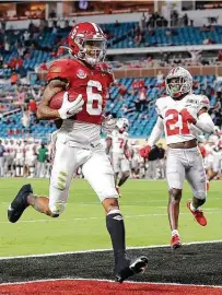  ?? Kevin C. Cox / Getty Images ?? Alabama’s Devonta Smith completes a 42-yard reception for one of his three first-half touchdowns Monday. The Heisman Trophy winner left the game with a hand injury in the second half but not before catching 12 passes for 215 yards.