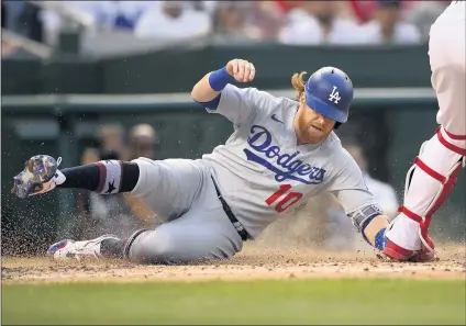  ?? PHOTOS BY NICK WASS — THE ASSOCIATED PRESS ?? The Dodgers’ Justin Turner slides home to score during the fourth inning of the team’s victory over the the Nationals on Saturday in Washington.