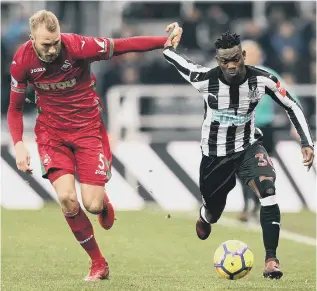  ??  ?? Newcastle winger Christian Atsu takes on Swansea’s Mike van der Hoorn earlier this month.