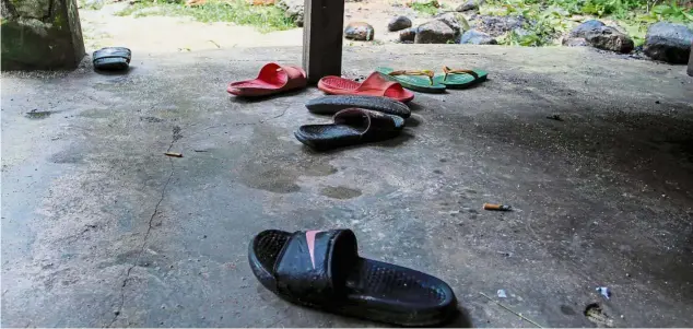  ??  ?? What remains: Footwear of the children left near the scene of the tragedy at Lubuk Semilang in Kuah.
