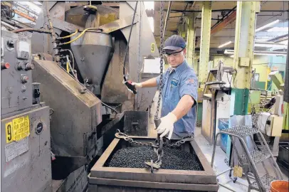  ?? CLOE POISSON | CPOISSON@COURANT.COM ?? MIKE DIETRICH, a grind operator at the Abbott Ball Co., attaches a hook to lift a 1,000-pound vat of carbon drill balls to pour into the grind machine behind him. Abbott Ball, which has been operating in West Hartford since 1909, manufactur­es more than 5 billion balls a year.