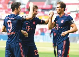  ??  ?? Robert Lewandowsk­i, left, of Munich, celebrates his team's fourth goal with teammates Thomas Mueller, centre, and Leon Goretzka during the match against Bayer Leverkusen. Photo: AP