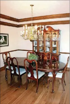  ??  ?? A slightly smaller version of the entry chandelier centers the double tray ceiling in the formal dining room.