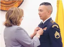  ?? GREG SORBER/JOURNAL ?? New Mexico Gov. Susana Martinez pins the Medal of Valor with Palm on Staff Sergeant Christophe­r Valdez of the New Mexico National Guard for stepping in to save two women from assault.