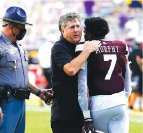  ?? AP PHOTO/GERALD HERBERT ?? Mississipp­i State coach Mike Leach hugs safety Marcus Murphy after the Bulldogs’ 44-34 victory over LSU on Saturday in Baton Rouge, La.