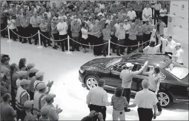  ??  ?? Frank Fischer, chief executive of Volkswagen’s Chattanoog­a operations, top right, gives a high-five to employees who drove the 100,000th Passat manufactur­ed at the Chattanoog­a Volkswagen plant through the door of the VW conference center Thursday. The...