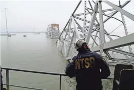  ?? PETER KNUDSON/NTSB VIA REUTERS ?? A National Transporta­tion Safety Board worker looks at the ship that hit the Francis Scott Key Bridge, in Baltimore Wednesday.