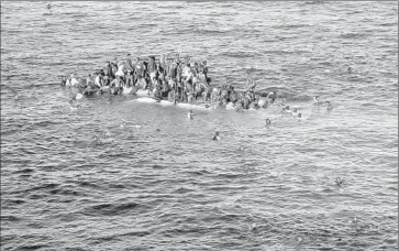  ?? Opielok Offshore Carriers ?? A CAPSIZED BOAT and the migrants on and near it are shown in an image taken from a German cargo ship attempting a rescue on April 12. As many as 1,500 migrants have died this year in the Mediterran­ean Sea.