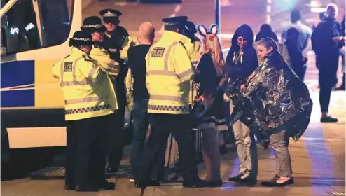  ?? PETER BYRNE / PA VIA ASSOCIATED PRESS ?? Au moins 19 personnes ont été tuées à la suite d’une explosion considérée comme un acte terroriste dans une salle de spectacle de Manchester. Sur la photo, des spectateur­s sont pris en charge par les forces policières.