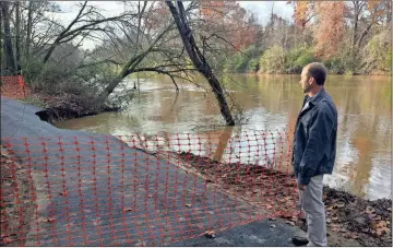  ??  ?? ABOVE: New Rome Street Department Director Chad Hampton surveys a section of trail below Chieftains Museum which washed out over the weekend.