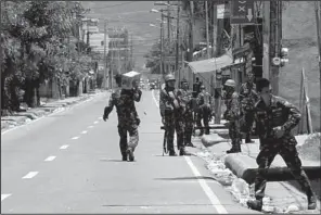  ?? AP/BULLIT MARQUEZ ?? Government troops patrol an area Saturday as fighting continues for the sixth day between the military and Muslim rebels in the southern Philippine­s.