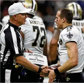  ?? CHRIS GRAYTHEN / GETTY IMAGES ?? The Saints’ Drew Brees receives the ball from referee Carl Cheffers after breaking the all time passing yards record against the Redskins on Oct. 8.