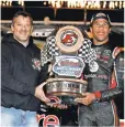  ?? SEAN GARDNER, NASCAR, VIA GETTY IMAGES ?? Eldora Speedway owner Tony Stewart, left, gives truck race winner Darrell Wallace Jr. his 2014 trophy.