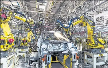  ?? UDIT KULSHRESTH­A — BLOOMBERG NEWS ARCHIVES ?? Robotic arms assemble an SUV on the production line at Mahindra &amp; Mahindra’s facility in Chakan, Maharashtr­a, India.