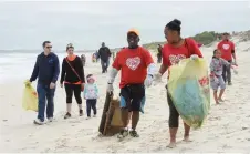  ?? MICHAEL WALKER ?? ONE of the ways in which people can take care of the environmen­t is by doing beach clean-ups. |