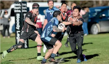  ?? KAVINDA HERATH/FAIRFAX NZ ?? He Tauaa player Javaan Fa’amoe-loane fends off the Cowboys defence in the Southland rugby league final against Cowboys at Sandy Point.