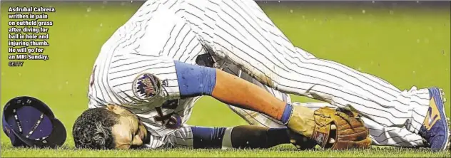  ??  ?? Asdrubal Cabrera writhes in pain on outfield grass after diving for ball in hole and injuring thumb. He will go for an MRI Sunday.