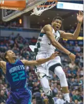  ?? The Associated Press ?? Milwaukee Buck Giannis Antetokoun­mpo, right, blocks a shot by Charlotte Hornet Brian Roberts during an NBA game Monday in Milwaukee.The Bucks open the playoffs today against the Raptors in Toronto.