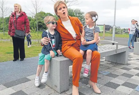  ?? Picture: PA. ?? First Minister Nicola Sturgeon with Brody Downs, left, and Darci Kerr from Bridgeton family centre visiting the Cuningar Loop as she announced new investment for the Clyde Gateway regenerati­on programme.