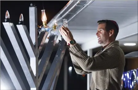  ?? BEN HASTY — MEDIANEWS GROUP ?? Magician Joshua Jay lights the menorah Wednesday, Dec. 1, during a Hanukkah celebratio­n at Chabad-Lubavitch of Berks County, Muhlenberg Township.