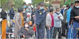  ?? (AFP) ?? People wait in a long queue along a street to take tests following a new outbreak of the COVID-19 coronaviru­s in Qingdao in China’s eastern Shandong province on Tuesday