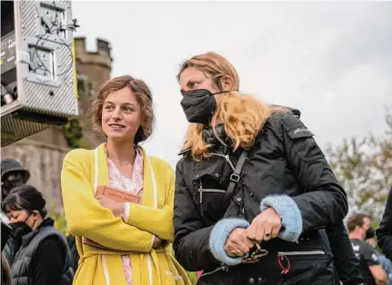  ?? Parisa Taghizadeh/Netflix ?? Director Laure de Clermont-Tonnerre (in mask) talks with actress Emma Corrin on the set of “Lady Chatterley's Lover.”