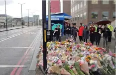  ??  ?? People lay flowers for victims of last Saturday’s attack on London Bridge, Monday, June 5, 2017.